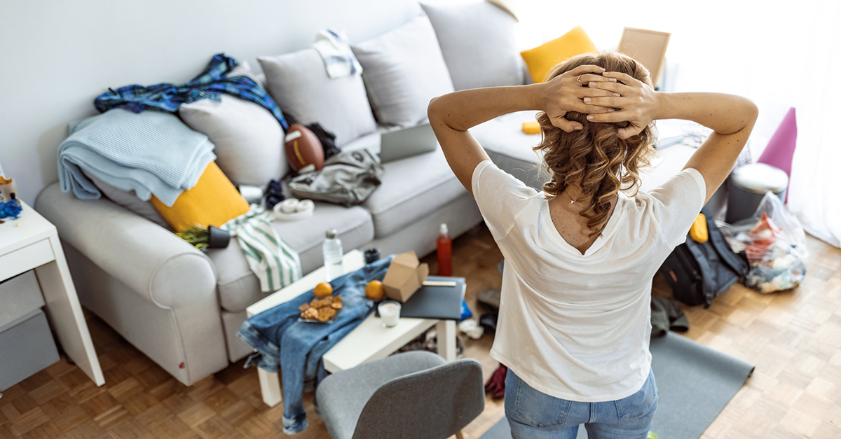 A woman is overwhelmed by her cluttered living room