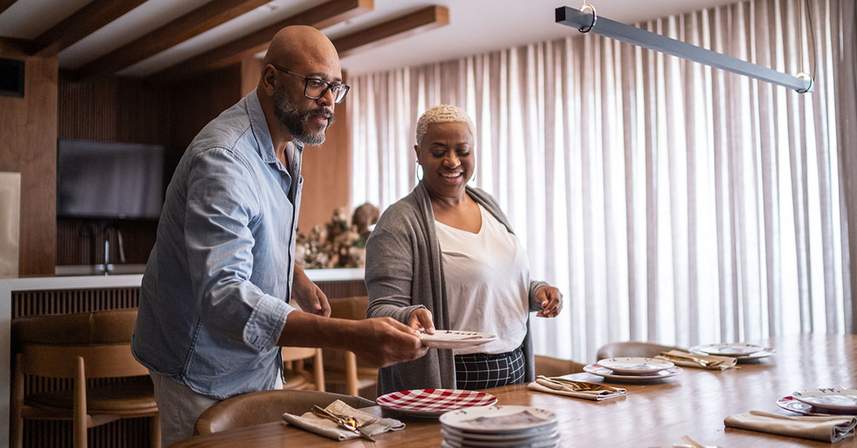 A couple setting the table for a family dinner