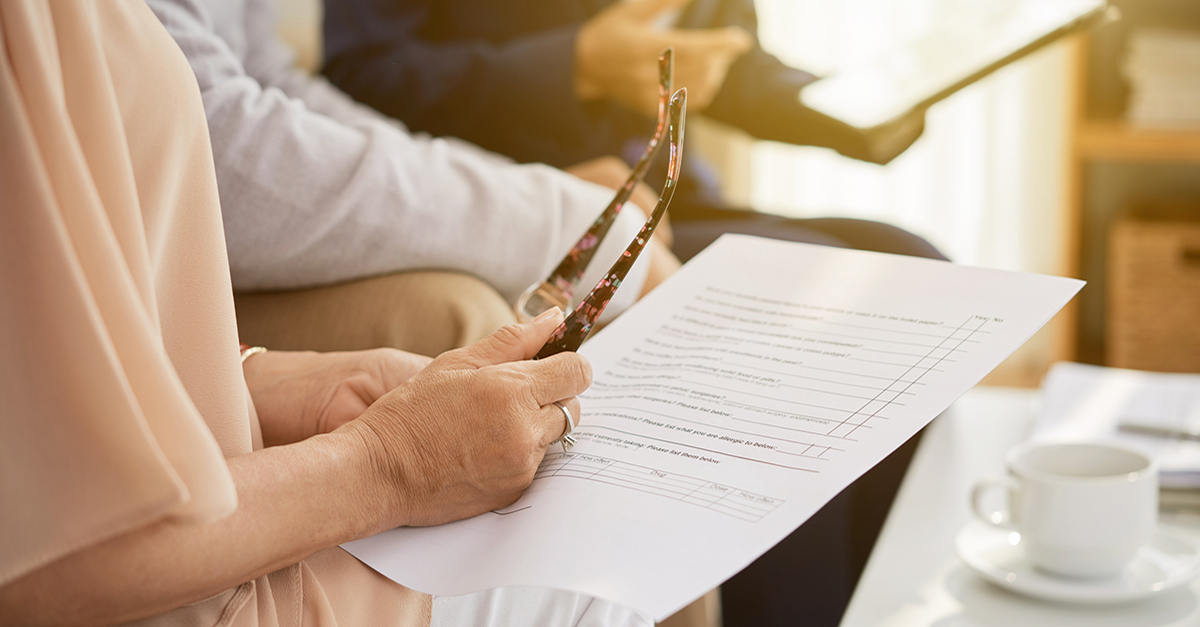 An elderly couple looking over title paperwork.