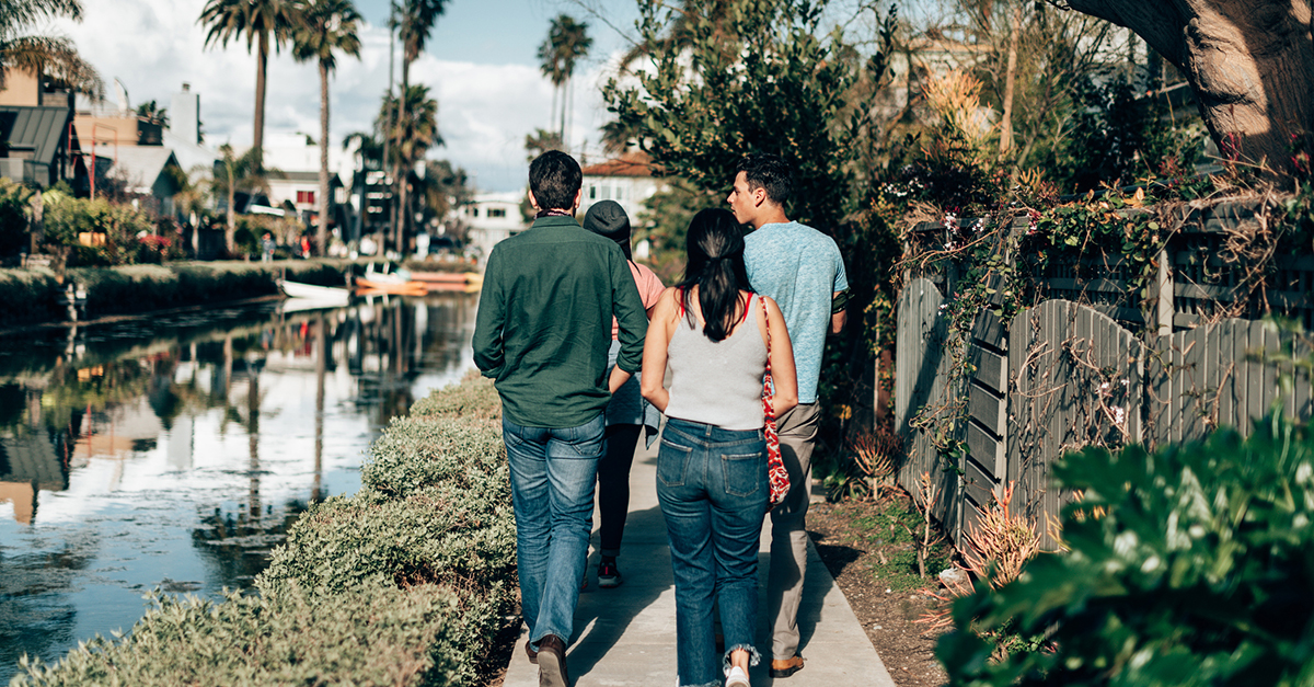 A group of friends walk together along a canal